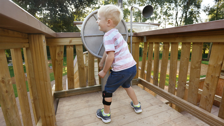 Child playing on a playground. He is wearing the WalkOn Reaction junior, a dynamic ankle-foot orthosis from Ottobock, on his left leg