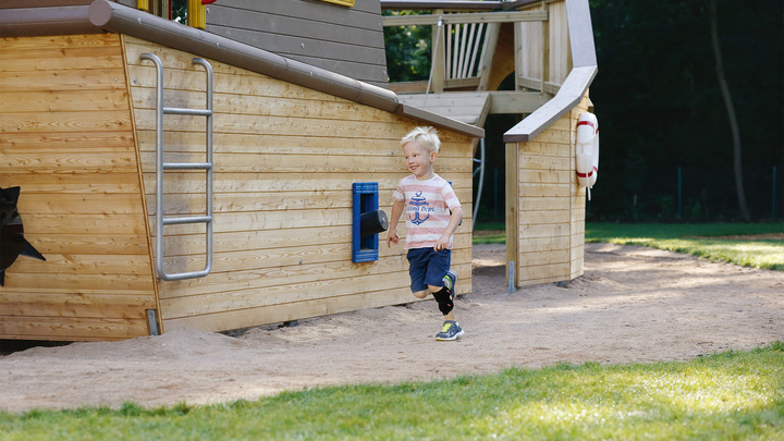 Child running across a playground. He is wearing the WalkOn Reaction junior, a dynamic ankle-foot orthosis from Ottobock, on his left leg