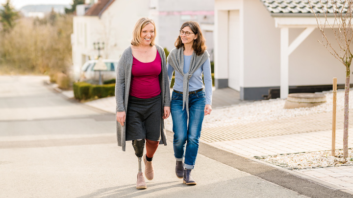Anita wears her Trias prosthetic foot as she strolls down the street with her friend Christine.
