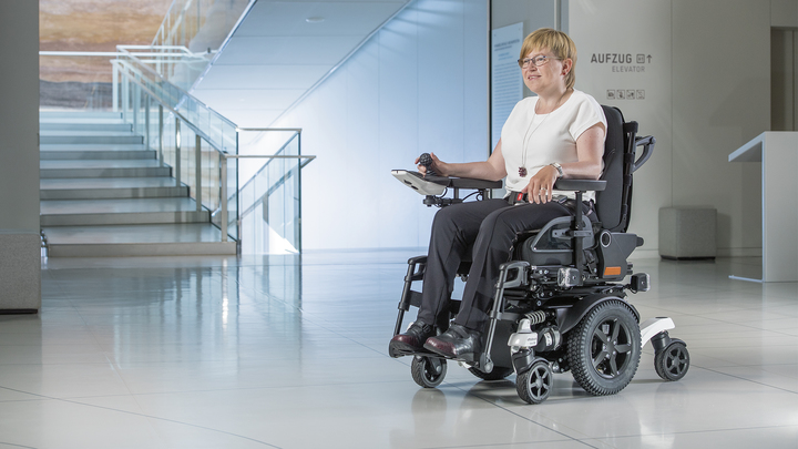 사용자와 함께 미술관에 있는 Ottobock 전동 휠체어 Juvo 후륜 구동.