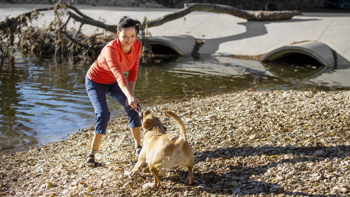 Cassie plays by the water with her dog.
