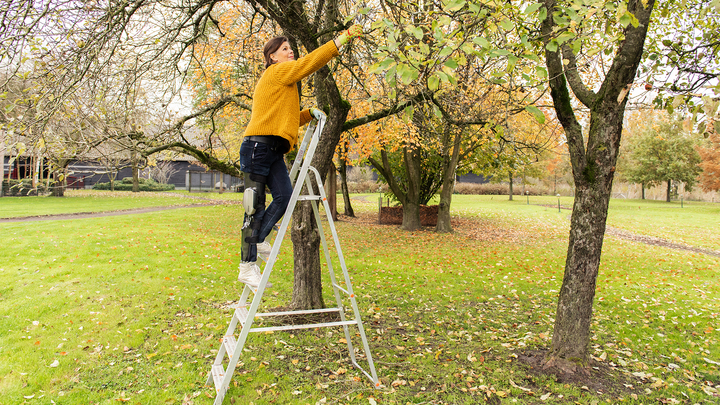 Marjan kan met haar lichte C-Brace® veilig op een ladder staan en zich op het tuinwerk concentreren.