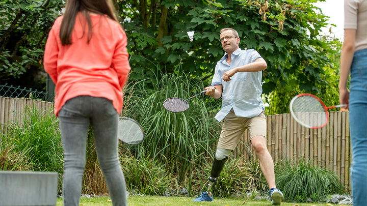 Peter spielt mit seinen Töchtern Federball im Garten.