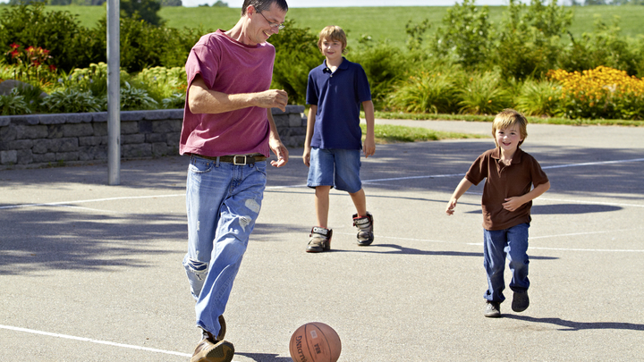 Rick plays football with his children