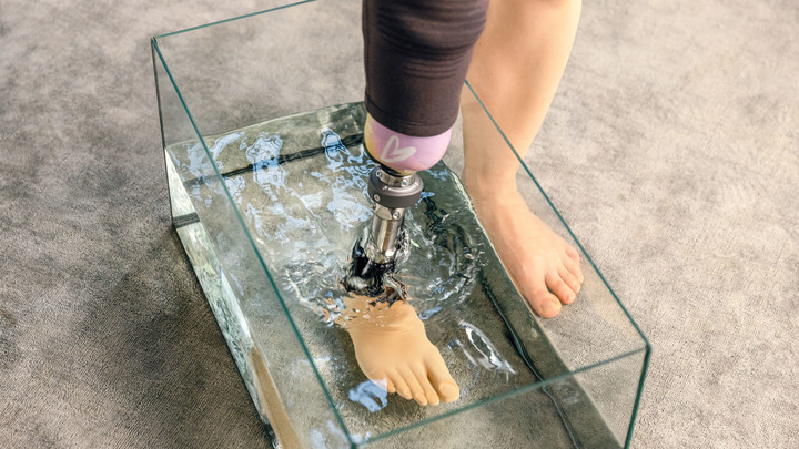 Close-up of Natálie's prosthetic leg in a water basin.