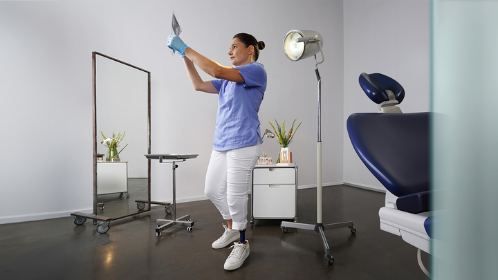 Eine weibliche Zahnärztin steht mit ihrem Ottobock Evanto Prothesenfuß und betrachtet eine Röntgenaufnahme.