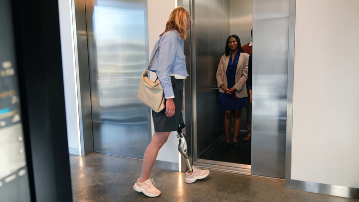 Genium X4 user Laura gets into the lift and takes the first step with her prosthesis side